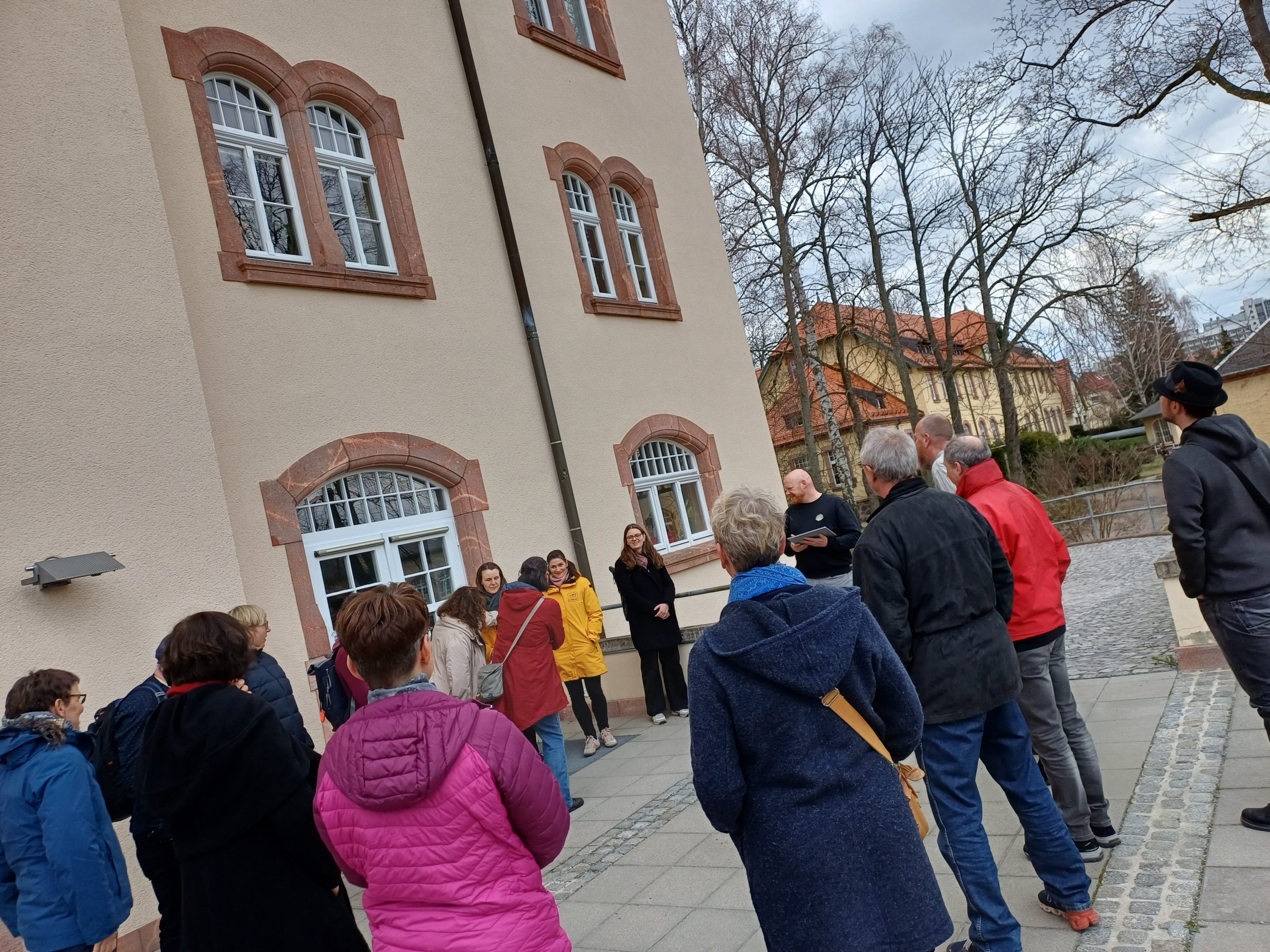 Eine Gruppe von Lehrer vor Haus 47 bei einer Führung über das Gelände