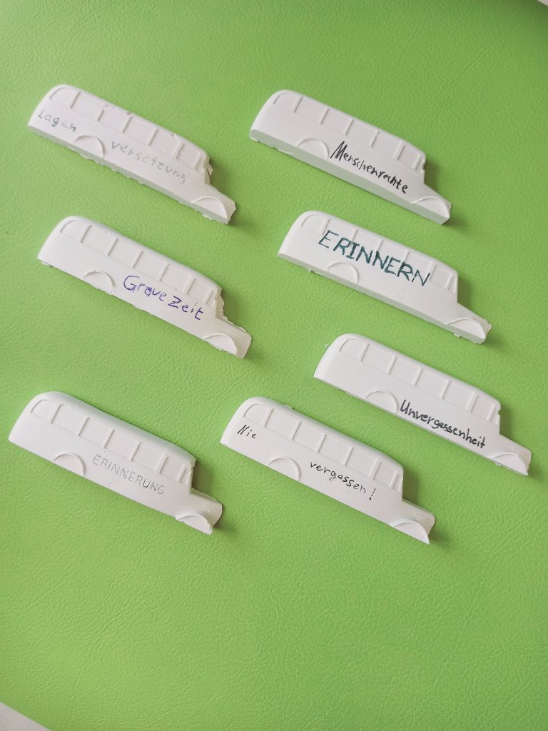Sieben kleine Gips-Busse, auf denen Botschaften zum Denkmal der Grauen Busse festgehalten sind.
