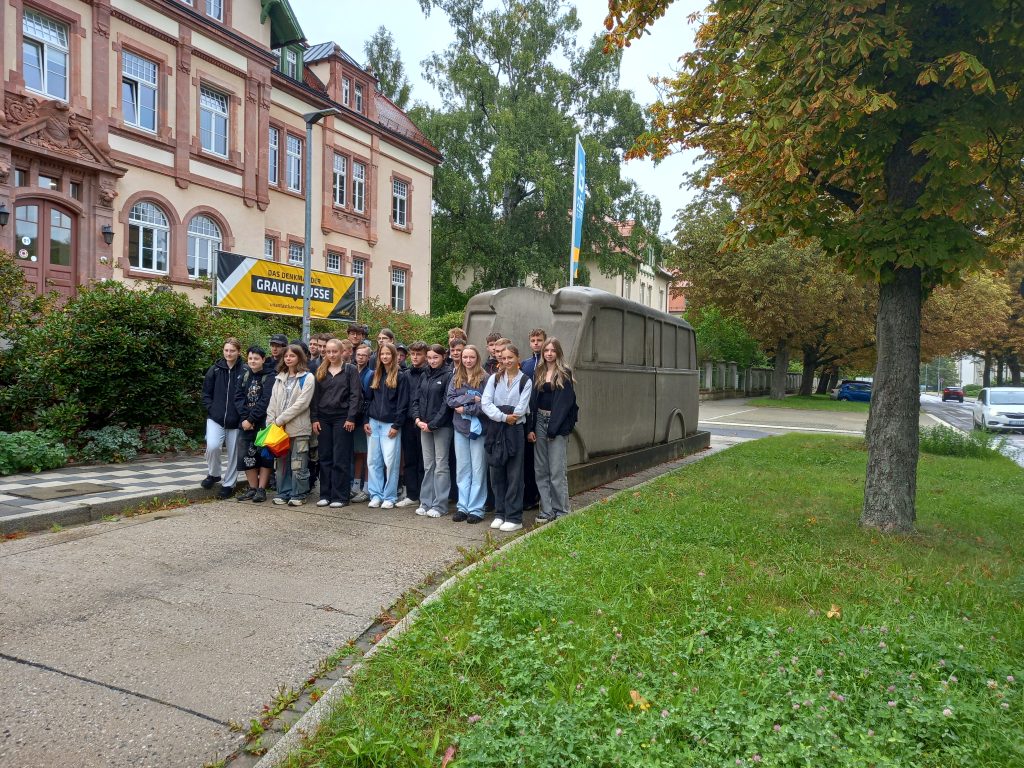 Gruppenfoto der Klasse 9b vor dem Denkmal der "Grauen Busse".