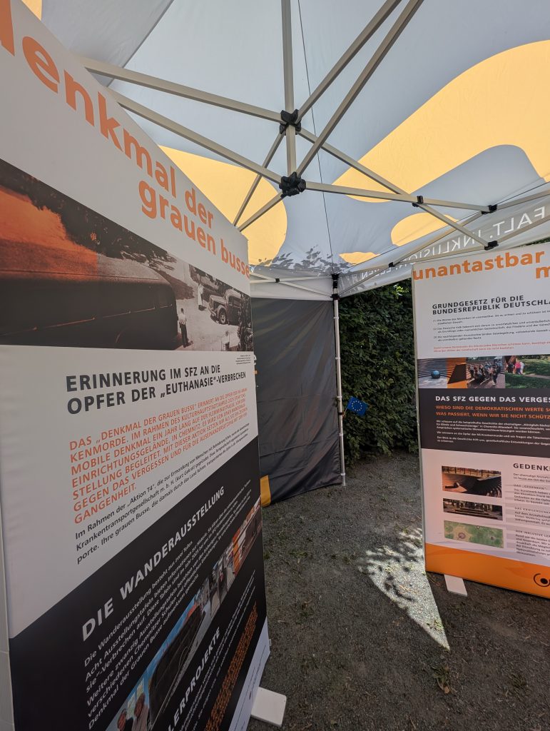 Zwei Aufsteller am Informationsstand geben Auskunft zum Denkmal der "Grauen Busse" und Unantastbar Mensch.