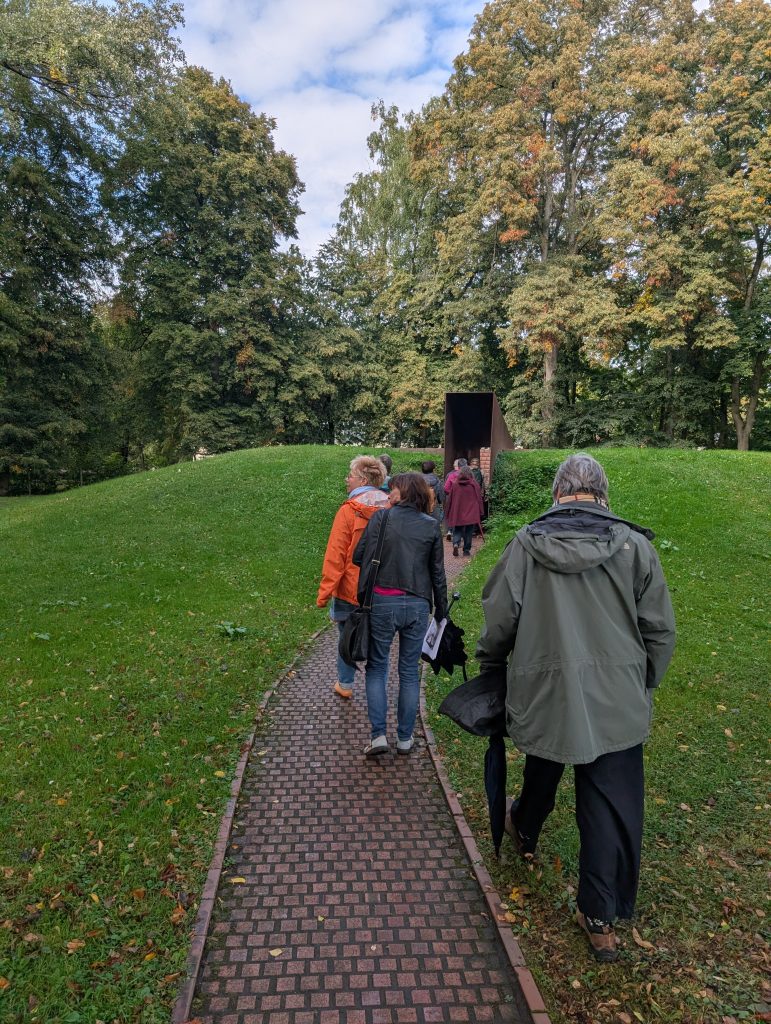 Eine Besuchergruppe läuft in das GEDENKEN hinein.